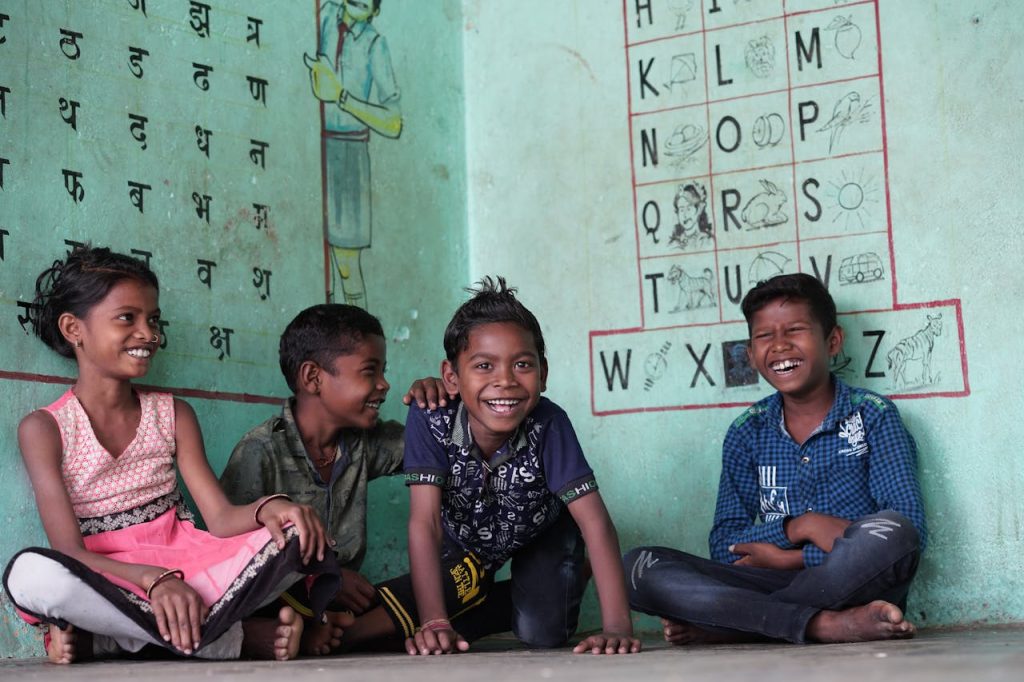 Group of happy Indian children sitting together, learning in a colorful school setting.